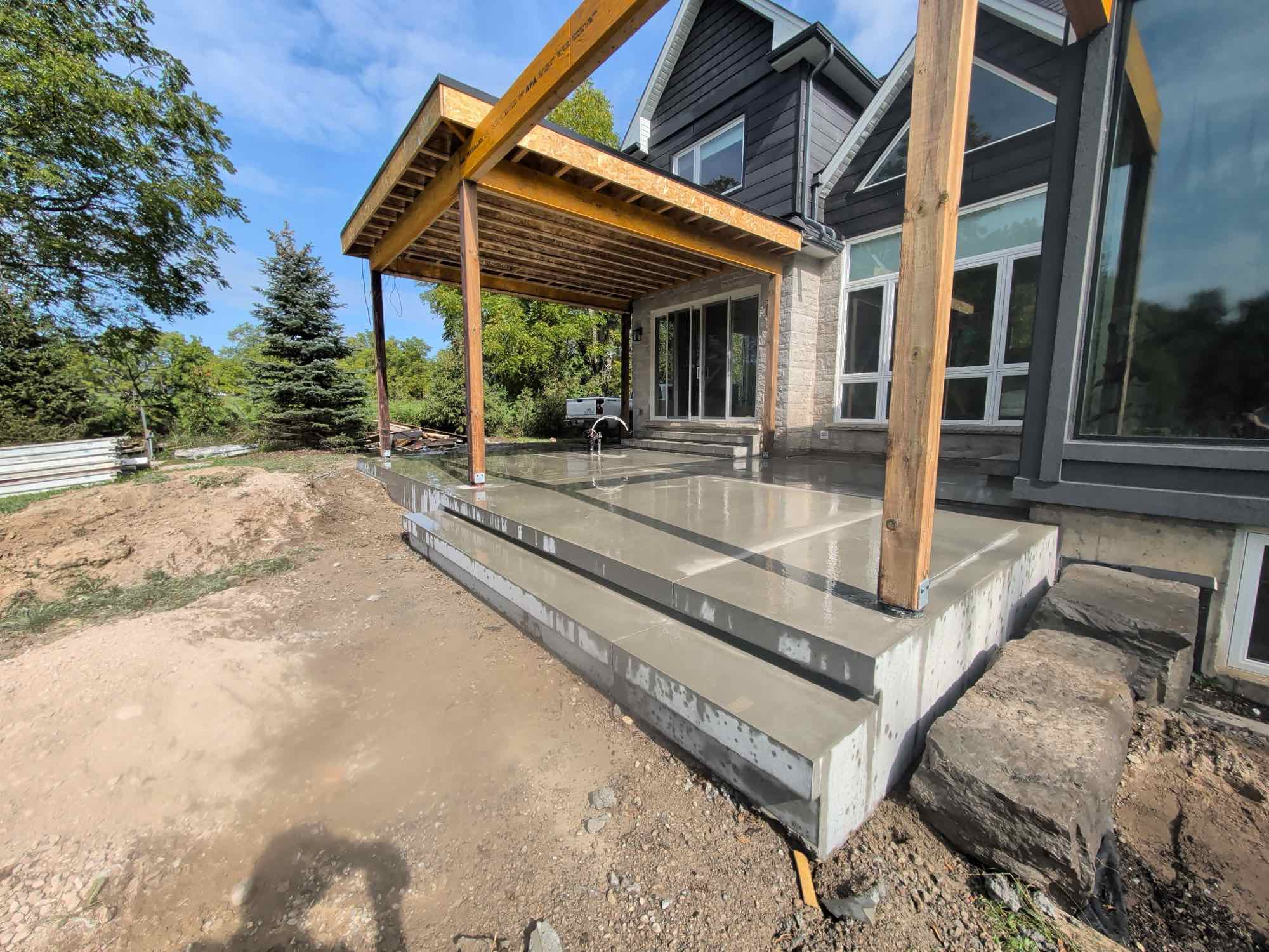 Country Estates Construction concrete work: new concrete porch and steps under a timber covered porch at a modern house