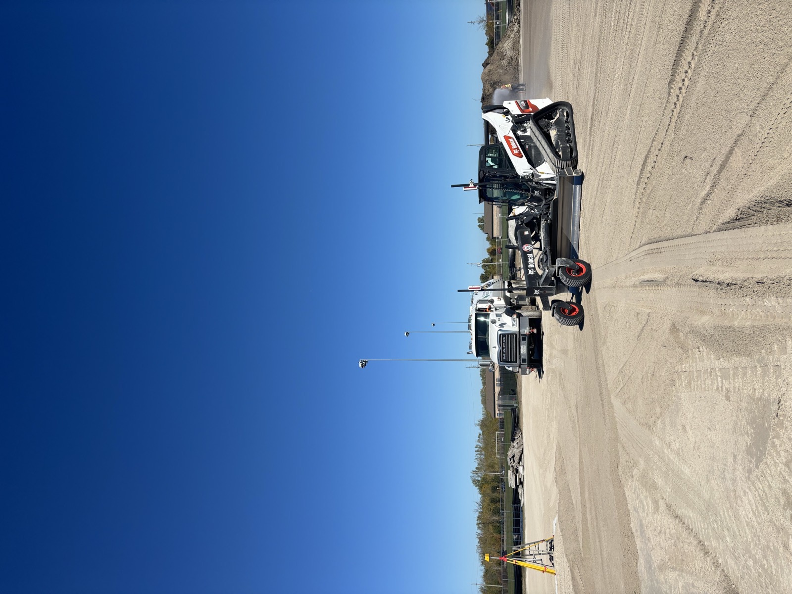 Bobcat grader and laser level on site