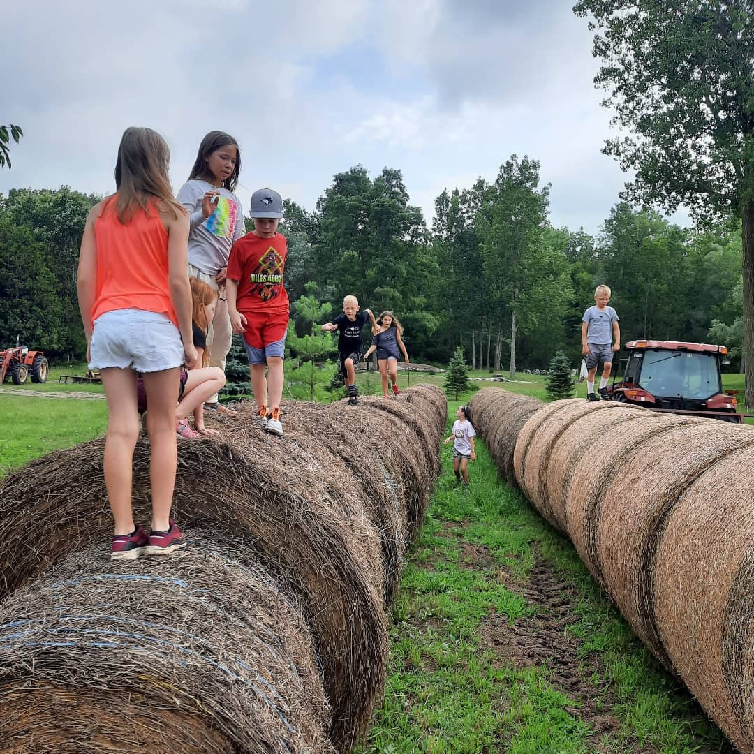 Campers balancing on hay bales