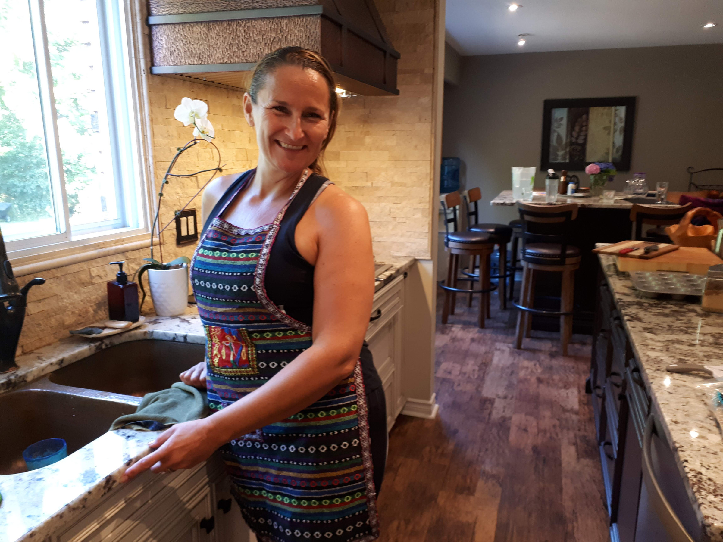 Kaley in an apron in her kitchen