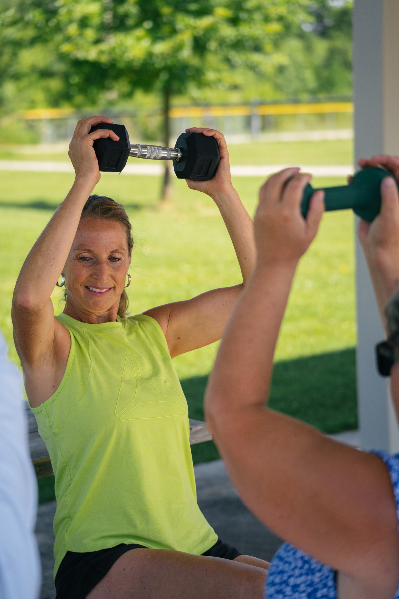 Kaley lifting dumbbells outdoors