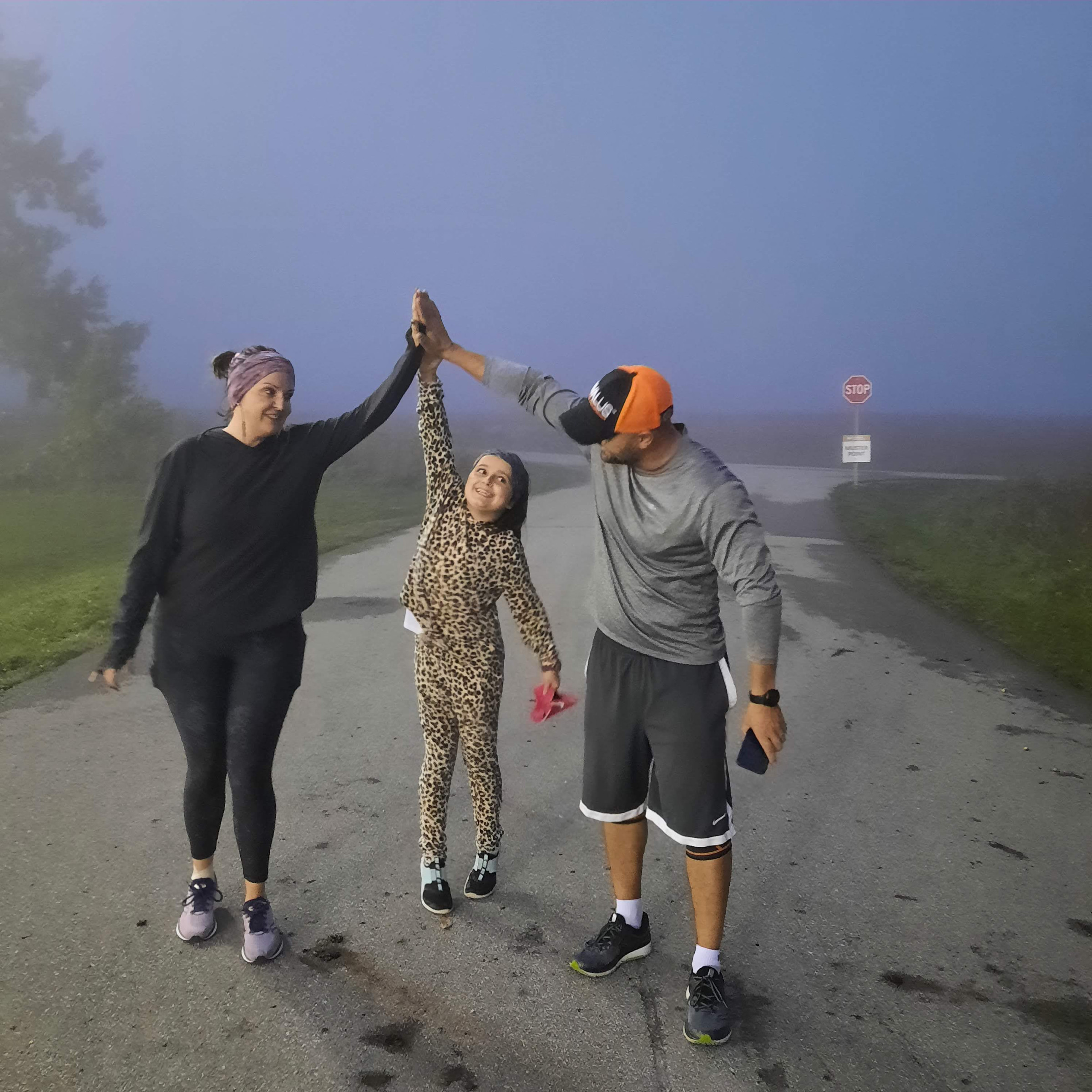 Two women high-fiving on a misty morning walk