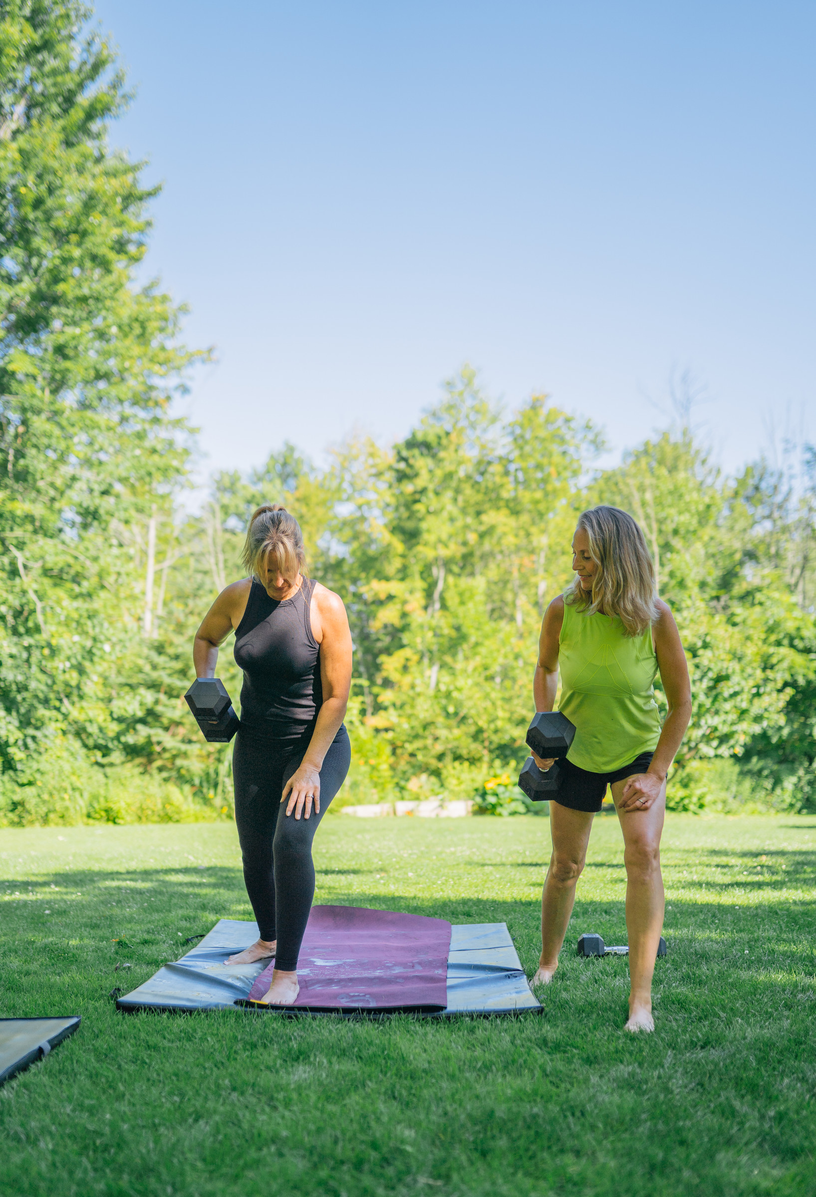 Two women training with dumbbells on a path