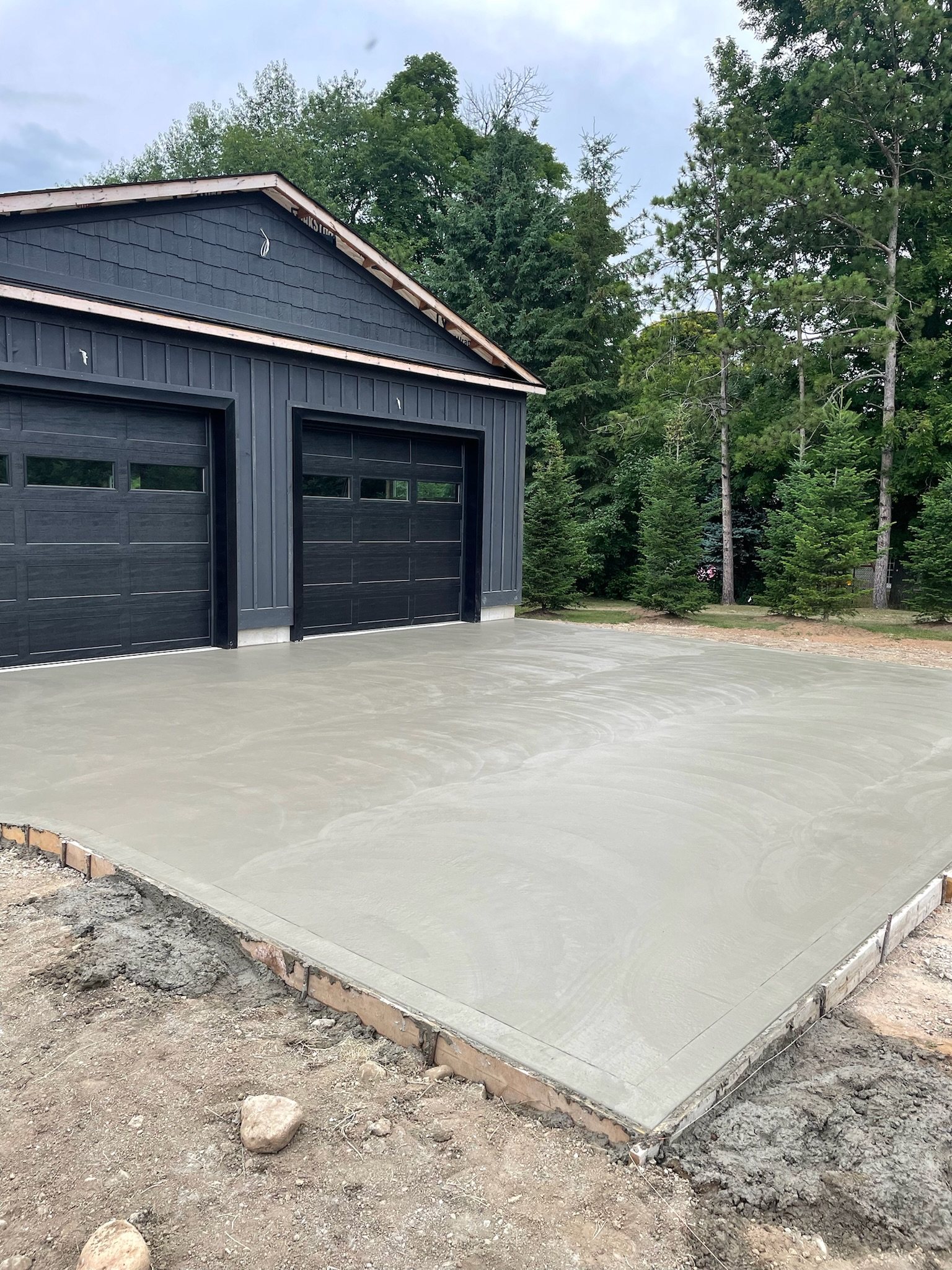 New concrete pad in front of a two-door garage