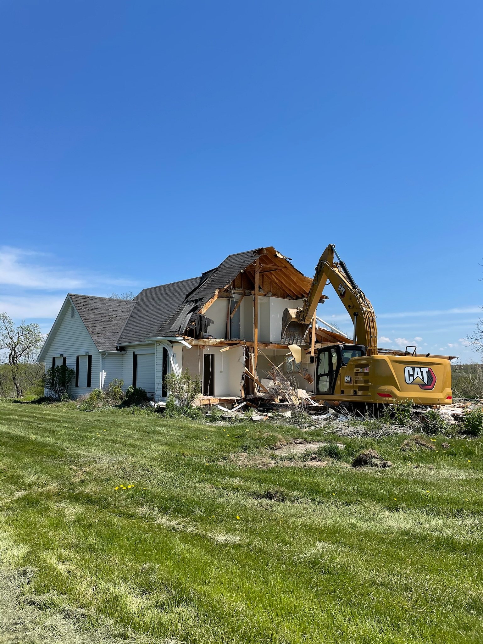 Excavator taking down an old house
