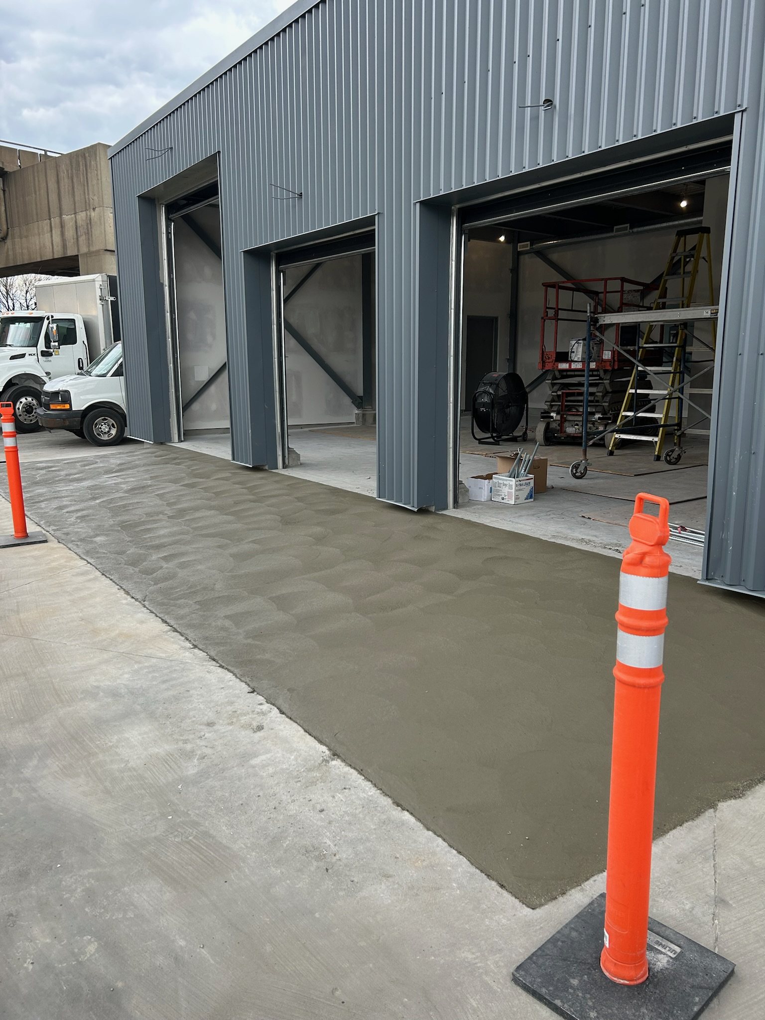 Fresh concrete apron at a steel building's overhead doors