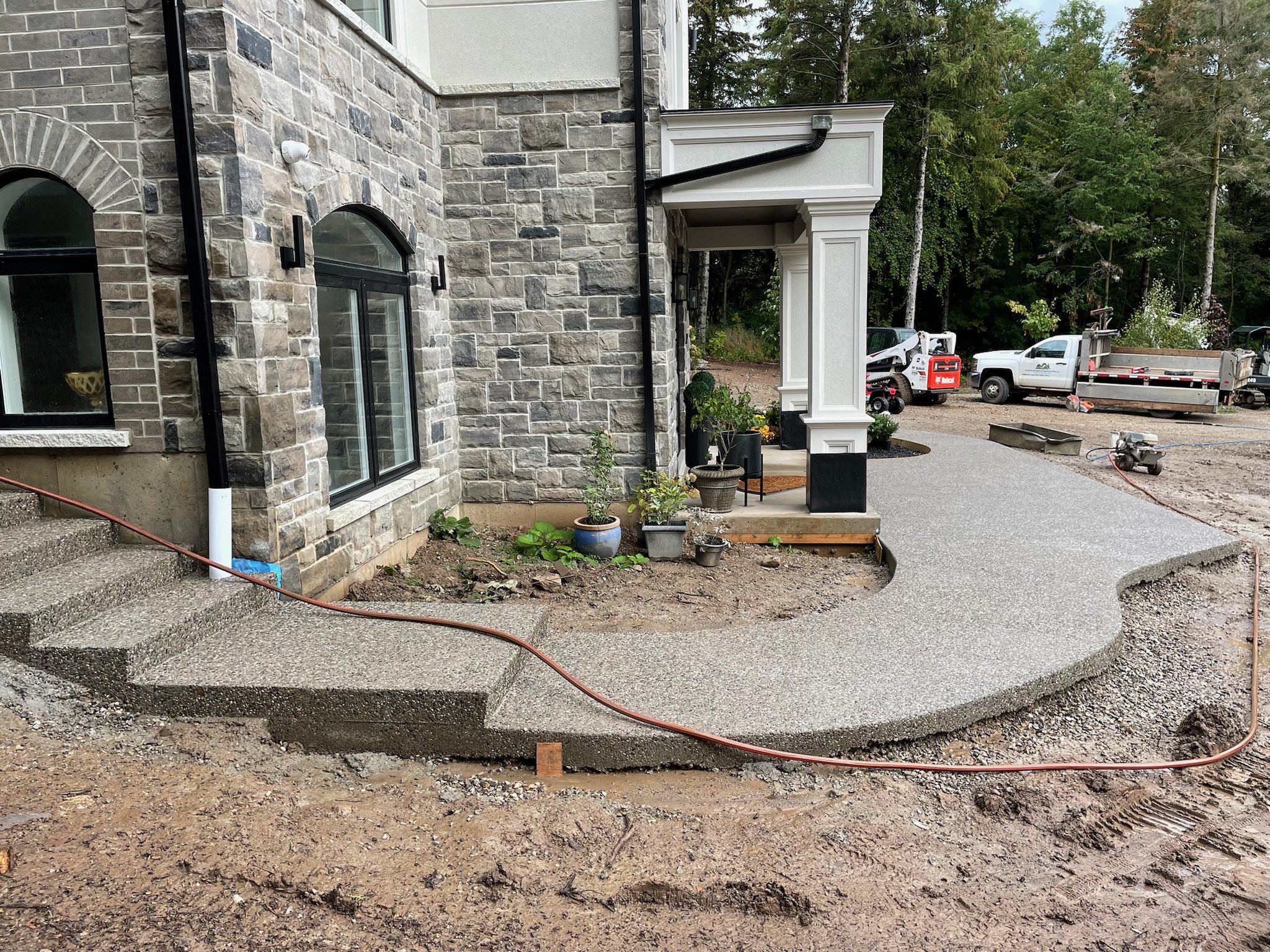 Curved exposed aggregate walkway at a stone house