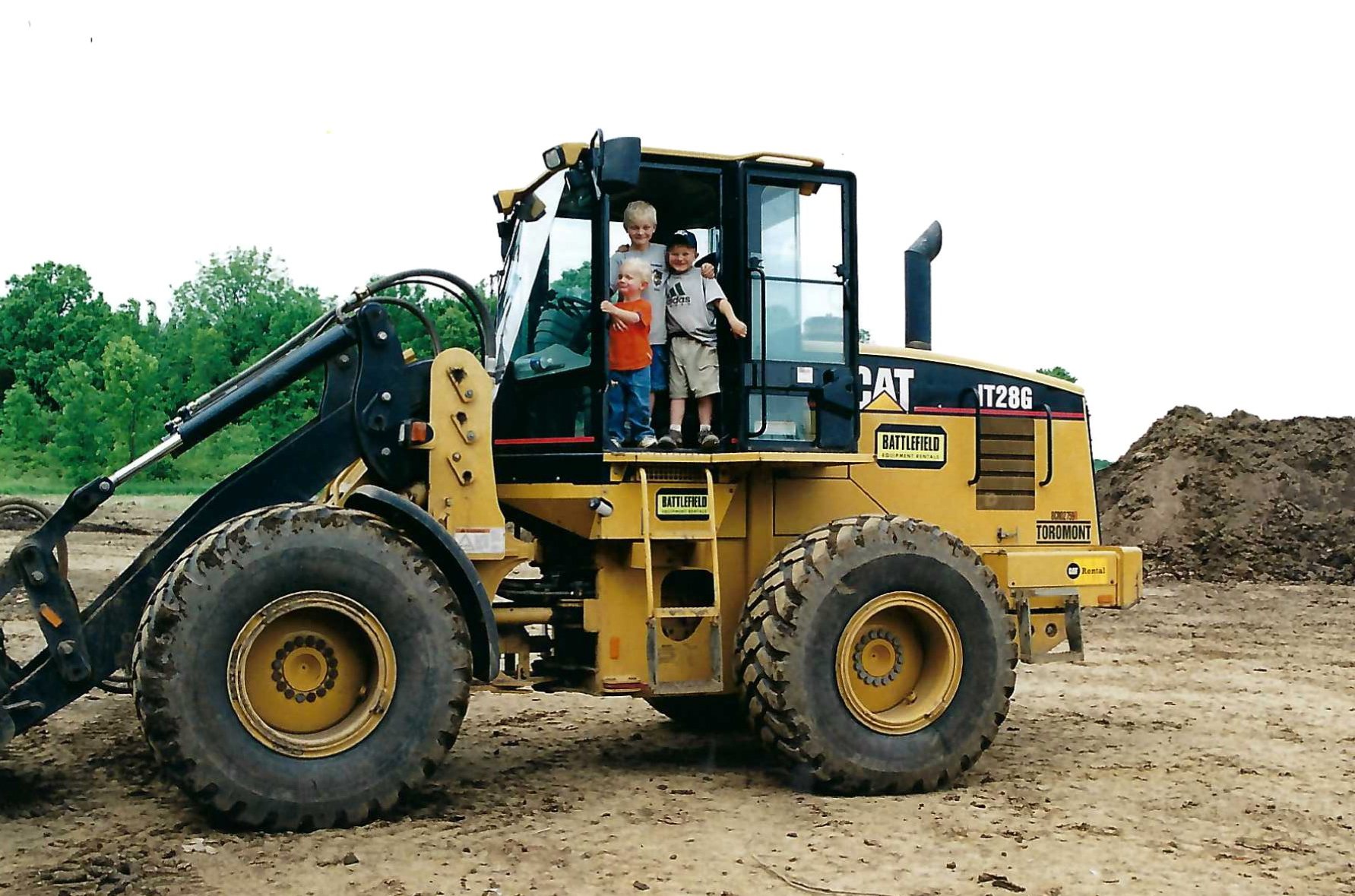 Two children in the cab of a wheel loader