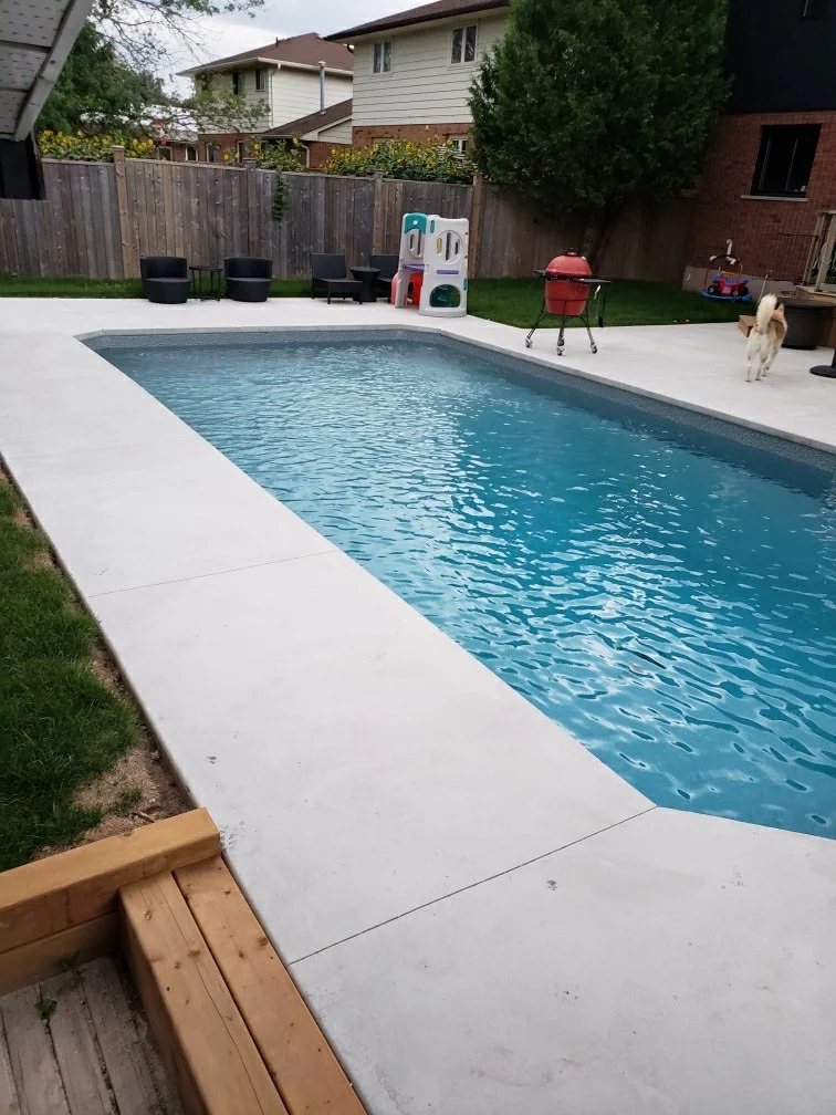 Concrete pool surround in a backyard