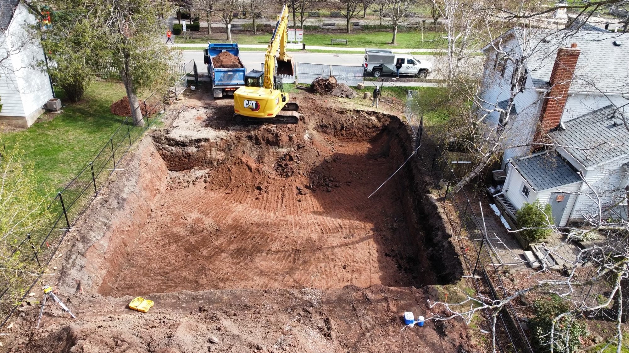 Aerial view of a finished excavation with an excavator and dump truck beside it