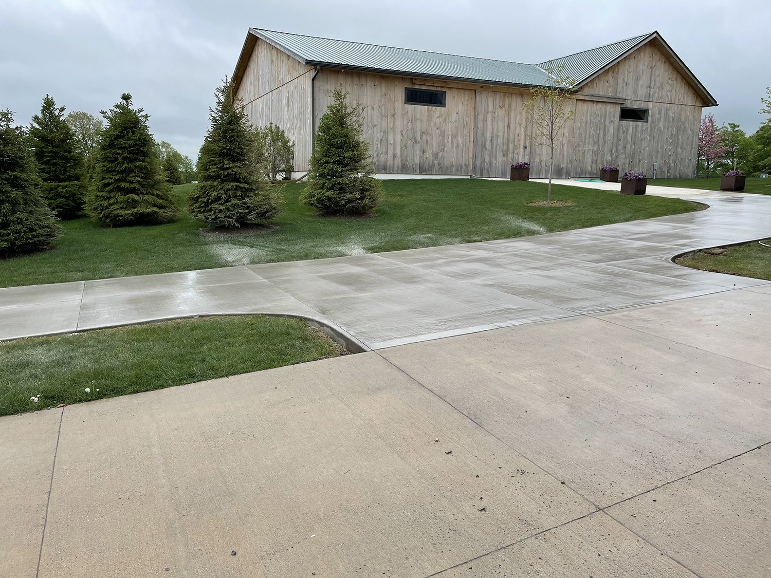 Long concrete driveway leading to a barn