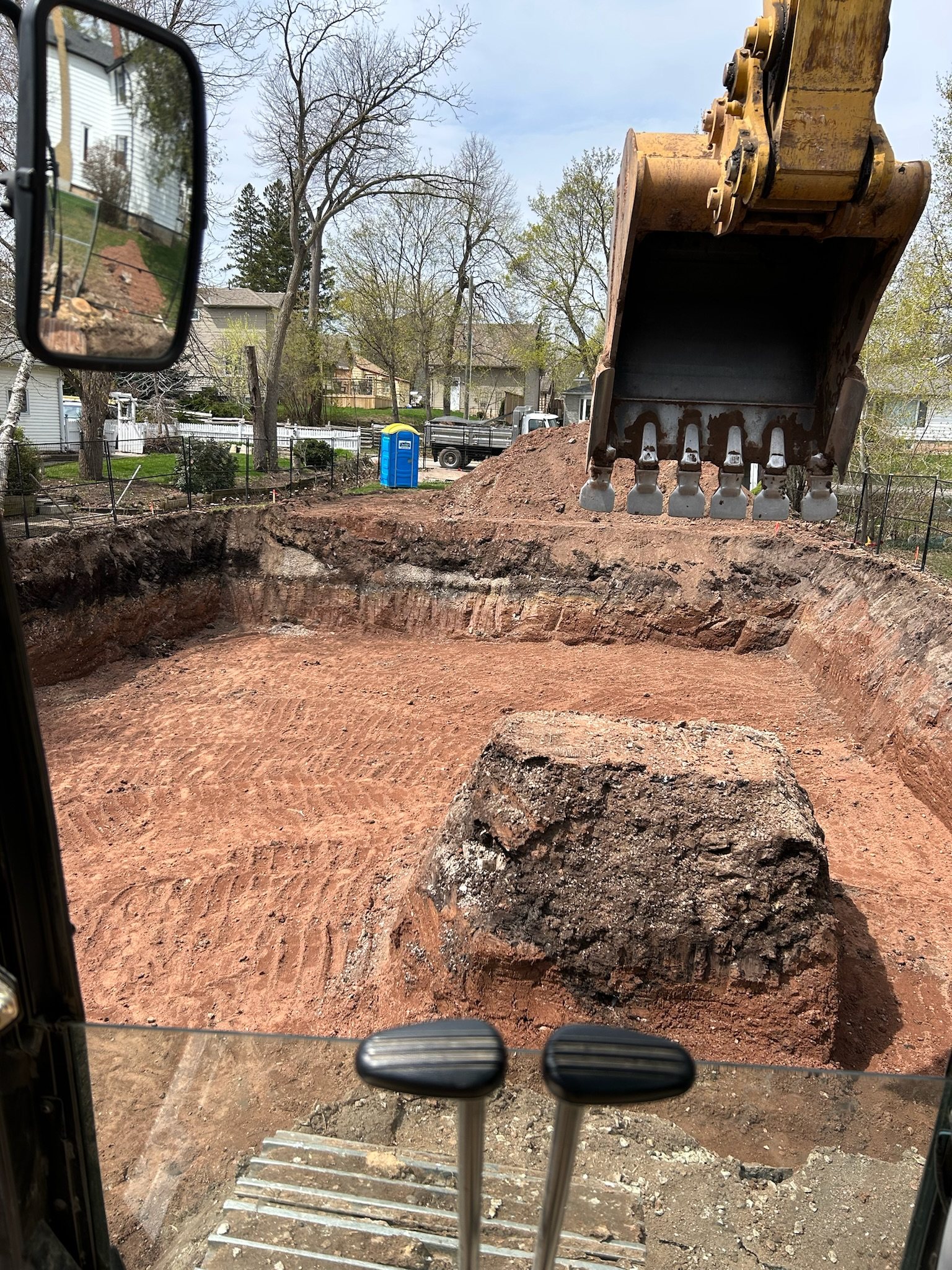 View from the excavator's cab over a dug foundation