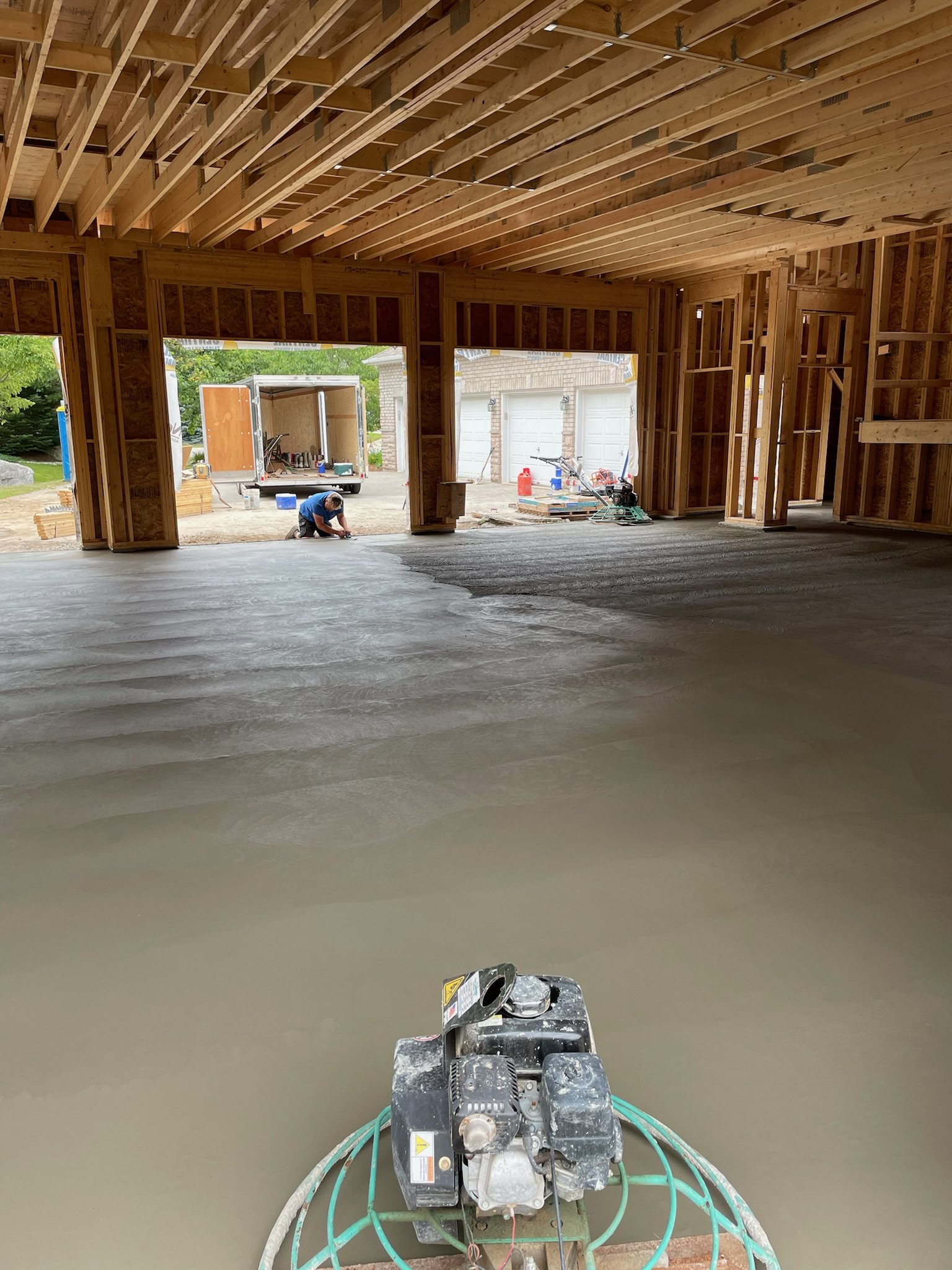 Power trowel finishing a new concrete floor in a house under construction
