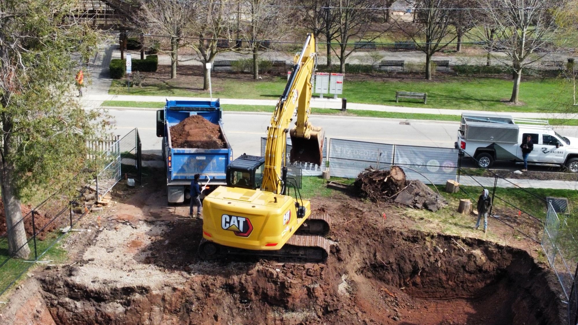Aerial view of an excavator loading a dump truck on a residential dig