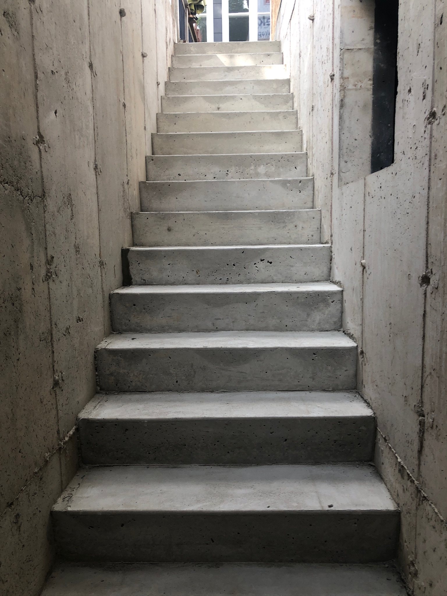 Poured concrete basement stairs between concrete walls