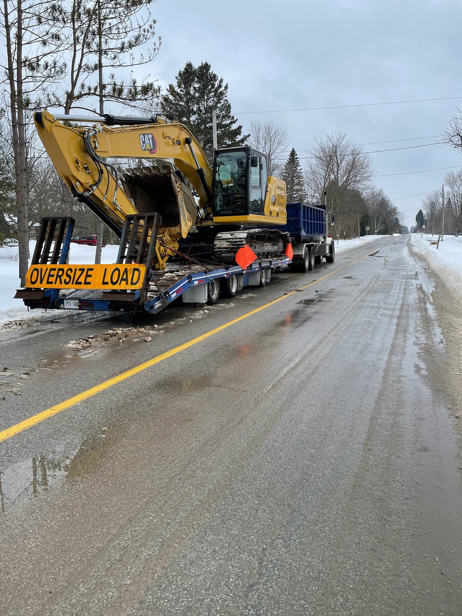 Excavator on a float marked oversize load