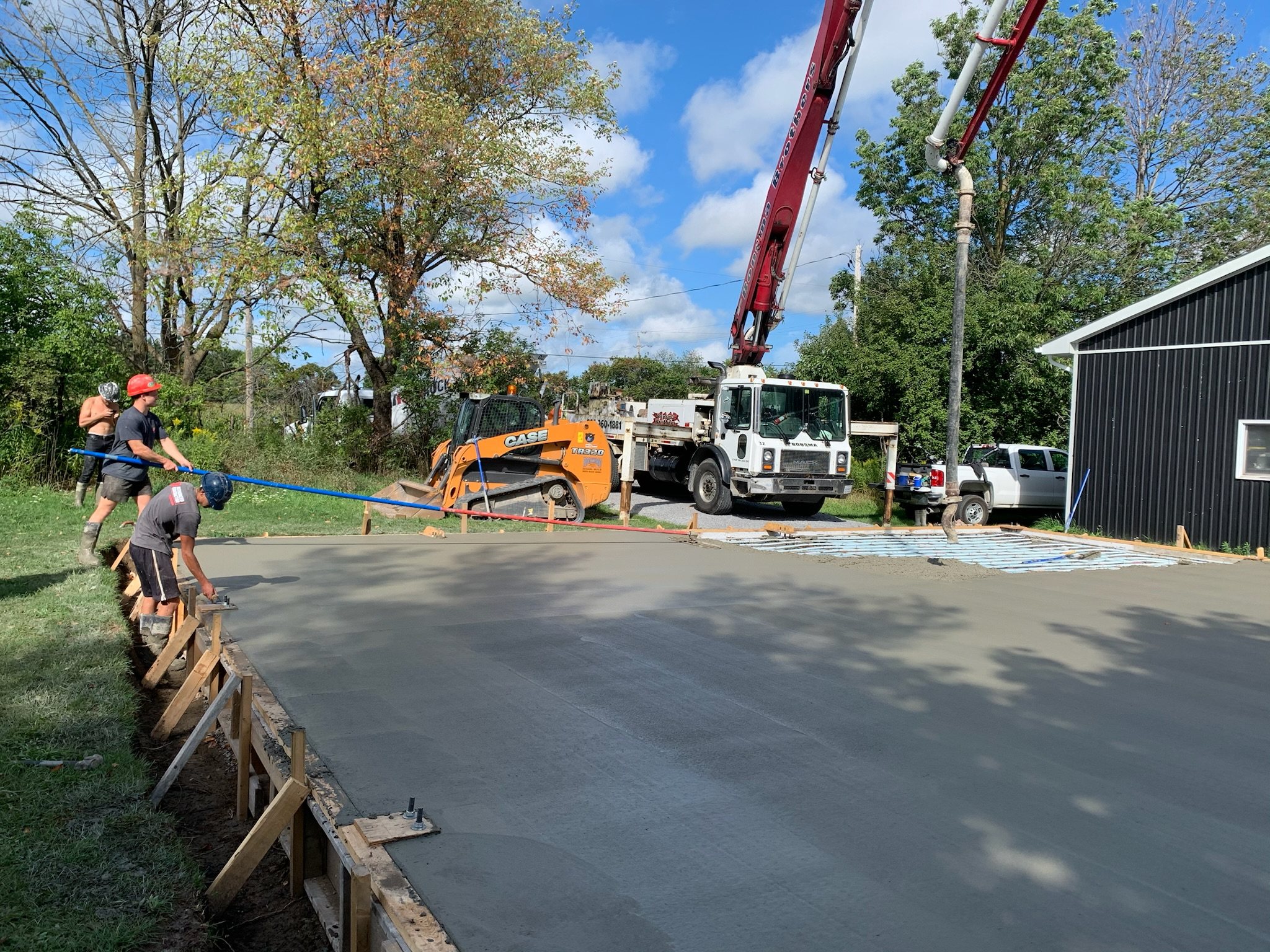 Crew placing a concrete slab from a pump truck