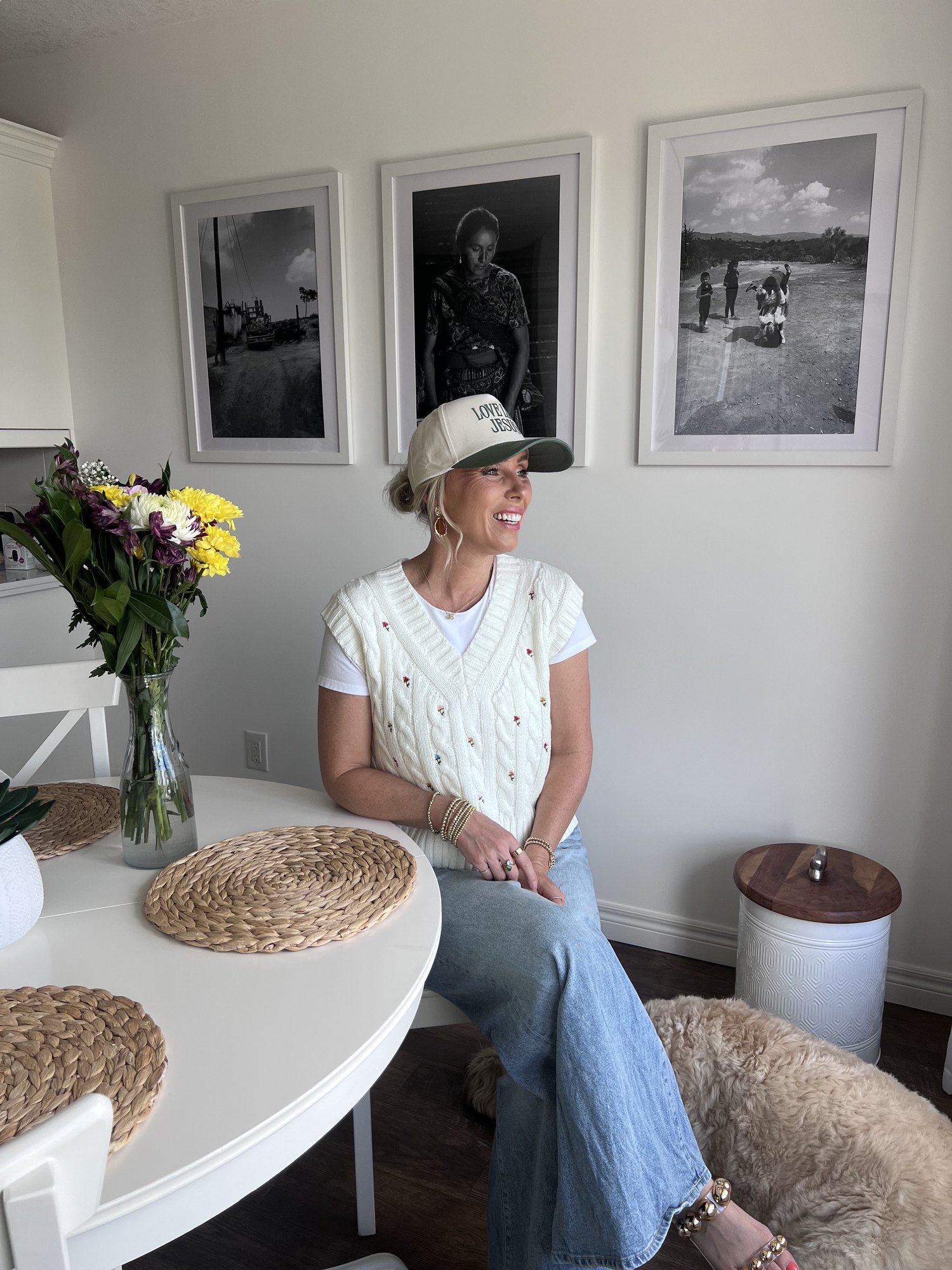 Mel at home, smiling beside a table of flowers