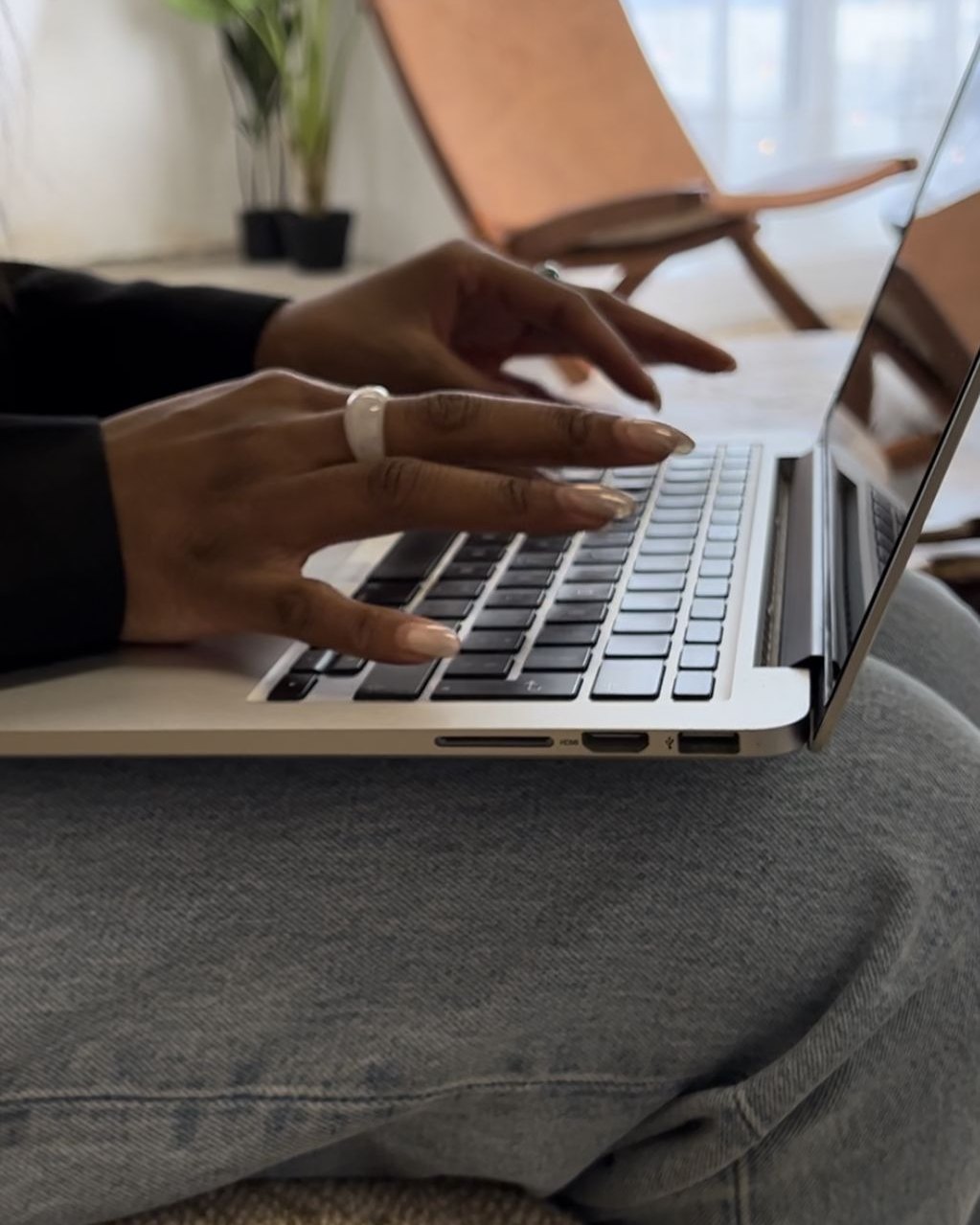 Hands typing on a laptop